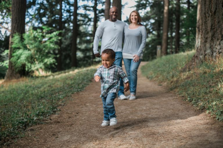 Mutter, Vater, Kind beim Spaziergang im Wald